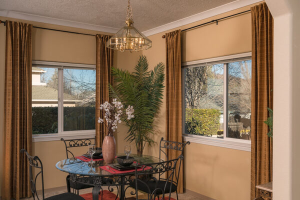 Dining area with round glass table, colorful rug