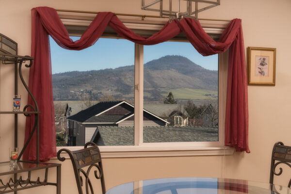 Dining room window with red curtains, mountain view