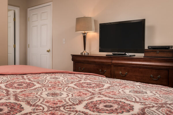 Bedroom with patterned bedspread and flat-screen TV