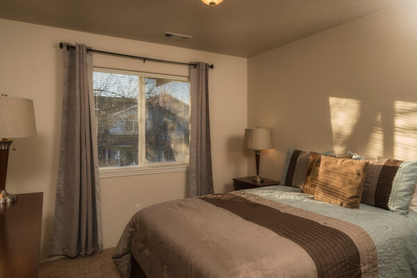 Cozy neutral bedroom with window and lamps