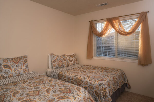 Twin bedroom with paisley bedding and window