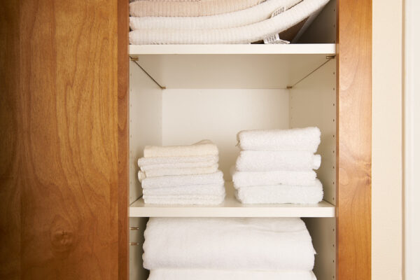 Wooden cabinet with neatly folded white towels
