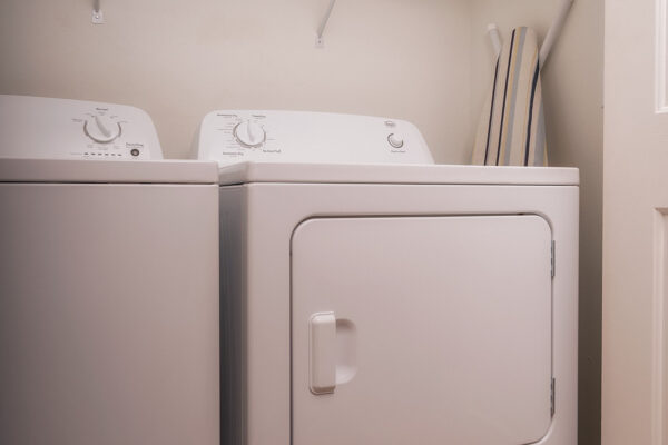 Compact laundry room with white washer and dryer