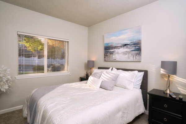 Cozy bedroom with white bed and painting